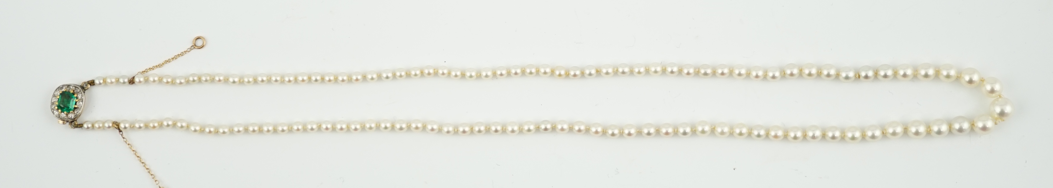 A single strand graduated cultured pearl necklace, with emerald and diamond cluster set gold clasp